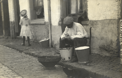 124990 Afbeelding van Johannes Bronius tijdens het schoonmaken van vis op de stoep voor zijn woning Koningstraat 46 te ...